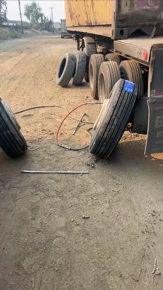 Roadside tire change on a loaded trailer on a dirt road