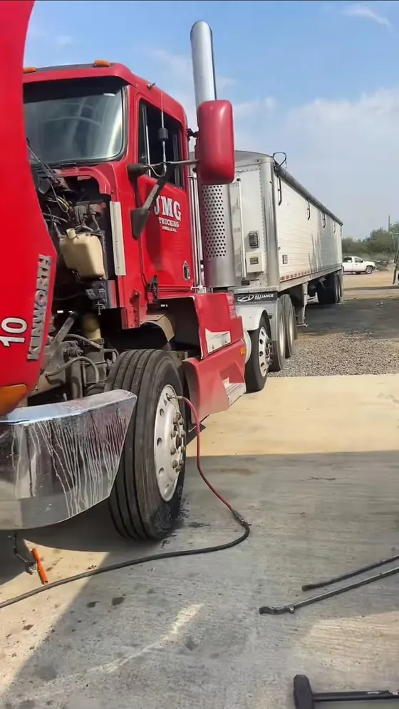 Red semi-truck with air hose connected during a steer tire service call