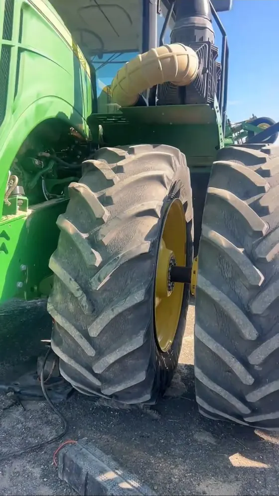Close-up of large agricultural dual tires on a green tractor during service